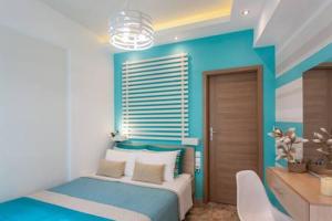 a blue bedroom with a bed and a desk at Kalyves Maisonette Bougainvillea in Kalyves