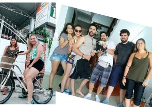 a group of people posing for a picture with a bike at Rubis Hostel in Hue