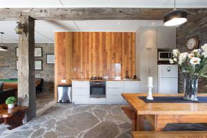 a kitchen with wooden cabinets and a table in a room at Creagh Cottage and Homestead in Arrowtown