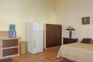 a bedroom with a white refrigerator and a bed at The Resort at Majahua Palms in Troncones