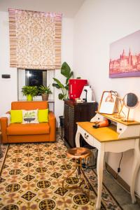 ein Wohnzimmer mit einem orangenen Stuhl und einem Schreibtisch in der Unterkunft City Dacha in Sliema