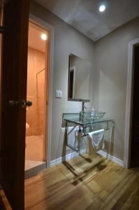 a glass desk in a bathroom with a shower at Suites del Sol in Tijuana