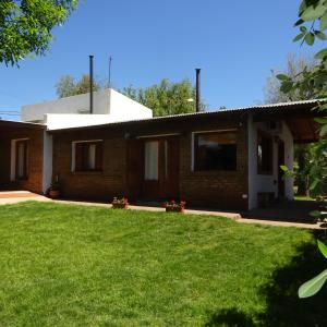 a house with a green lawn in front of it at casa barrio golf in Tandil