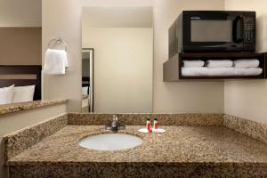 a bathroom with a sink and a microwave at Baymont by Wyndham Wellington in Wellington +17 photos