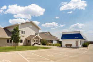 a house with a blue awning and a parking lot at Travelodge by Wyndham Bill WY Thunder Basin Ntl Grassland in Bill