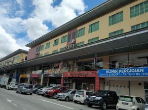 eine Reihe von Autos, die vor einem Gebäude geparkt sind in der Unterkunft Celyn Hotel City Mall in Kota Kinabalu