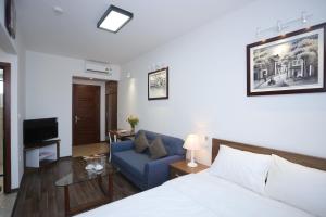 een woonkamer met een bed en een blauwe bank bij Cat Linh ARL55 Hotel in Hanoi