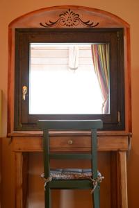 einen Stuhl vor einer Kommode mit einem Spiegel in der Unterkunft Casa Dolce Casa in Vercana