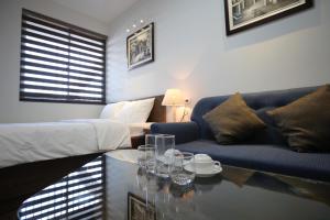een woonkamer met een bank en een tafel met glazen erop bij Cat Linh ARL55 Hotel in Hanoi