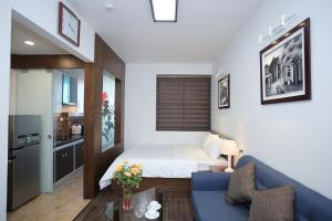 a hotel room with a bed and a blue couch at Cat Linh ARL55 Hotel in Hanoi