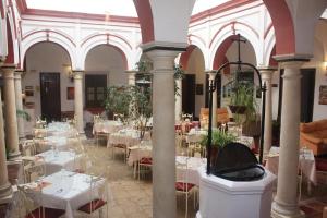 een kamer gevuld met tafels en stoelen met witte tafelkleden bij Hotel Marqués de Torresoto by Vivere Stays in Arcos de la Frontera