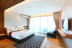 a hotel room with a bed and a television at Montana Hotel Songkhla in Songkhla