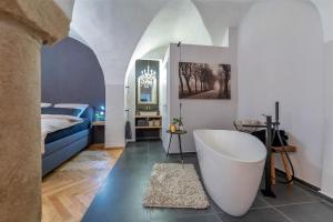 ein Bad mit Badewanne und ein Bett in einem Zimmer in der Unterkunft Passau42 in Passau