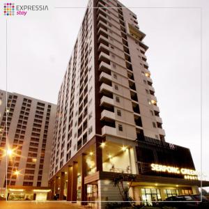 een hoog gebouw met een bord aan de zijkant bij Expressia Stay at Serpong Greenview Apartment in Serpong