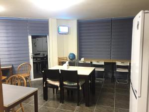 a dining room with tables and chairs and a tv at Jeju Guesthouse in Jeju