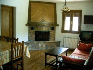 a living room with a fireplace and a table at Apartamentos Arcos de Solana in Vilas del Turbon