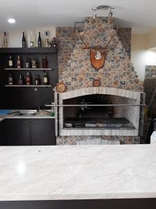 a stone fireplace in a kitchen with a counter at Hotel Toni in Bukovlŭk