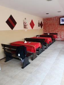 a restaurant with red tables and benches in a room at Hotel Toni in Bukovlŭk