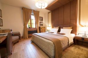 1 dormitorio con 1 cama grande y escritorio en Hotel Grad Otočec - Relais Chateaux, en Otočec