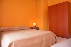 a bedroom with orange walls and a bed and a cabinet at Villa Roma - Negombo in Negombo