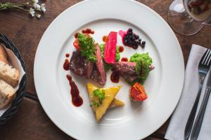 a plate of food with meat and vegetables on a table at Hotel Icefiord in Ilulissat