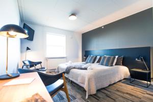 a bedroom with a bed and a blue wall at Hotel Icefiord in Ilulissat