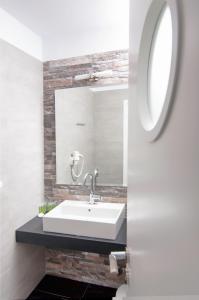 a bathroom with a white sink and a mirror at Skopelitis Village in Katapola