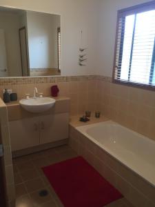 a bathroom with a sink and a tub and a mirror at Private Room In Everton Hills in Brisbane