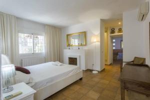 - une chambre avec un lit blanc et une cheminée dans l'établissement Villa Savines is a luxury villa close to Ibiza Town and Playa Den Bossa, à Ibiza 10 autres photos