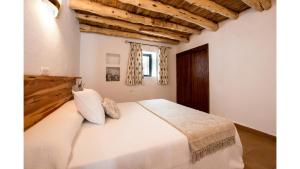 サンタ・エウラリア・デス・リウにあるVilla Can Reietの木製の天井の客室で、ベッドルーム1室(白いベッド1台付)