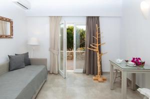 a bedroom with a bed and a table and a window at Skopelitis Village in Katapola
