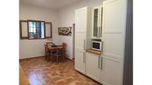 une cuisine avec des armoires blanches et une table dans l'établissement Can Tunicu has amazing sea views and is located in a quiet area near to San Antonio, à Sant Antoni de Portmany