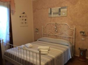 a bedroom with a bed with towels on it at Bed and Breakfast Val Di Lupa in Castellina Marittima