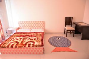 a bedroom with a bed and a desk and a chair at House of Traditions - Family Suite in Islamabad