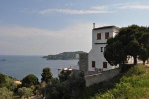 a white building on a hill next to the water at Villa Kim in Achladies