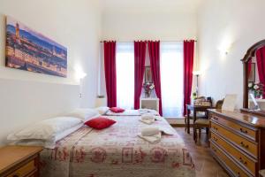a hotel room with a bed, desk, and bedside table at Guesthouse Bel Duomo in Florence