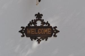 a welcome sign is hanging on a wall at Villa Kim in Achladies