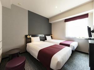 東京にあるヴィラフォンテーヌ東京浜松町のベッド2台と窓が備わるホテルルームです。