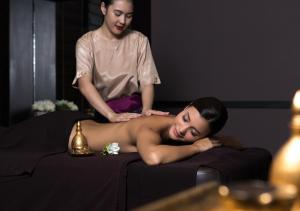 a woman giving a man a massage on a bed at U Chiang Mai in Chiang Mai