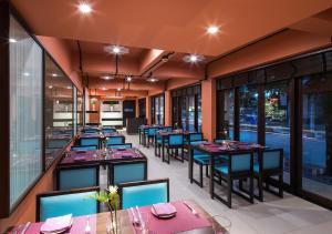 a restaurant with tables and chairs and windows at U Chiang Mai in Chiang Mai