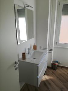 a white bathroom with a sink and a mirror at Appia Garden in Rome