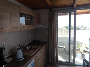 a kitchen with a sink and a sliding glass door at Hotel Aglaia in Kalamaki