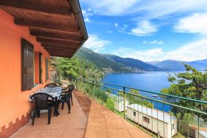 balcón con mesa, sillas y vistas al agua en Lakeview Cannobio Camping & Resort en Cannobio