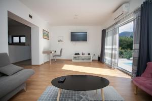 a living room with a table and a large window at Villa Zrinka **** in Svinišće
