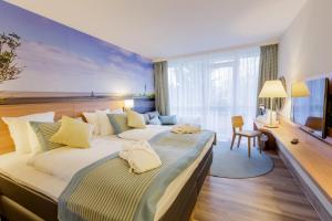 a hotel room with two beds and a desk at Hotel Nordseeküste by Center Parcs in Tossenserdeich