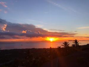 a sunset over the ocean with the sun setting at Samui Paradise Village in Nathon