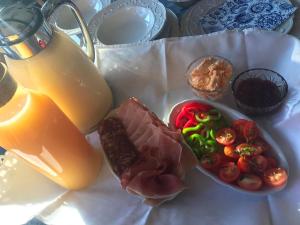 einen Teller mit Essen, einen Drink und eine Schale Gemüse in der Unterkunft Ubytovanie Meba in Prešov