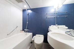 a bathroom with a tub and a toilet and a sink at Hotel Villa Fontaine Tokyo-Hamamatsucho in Tokyo