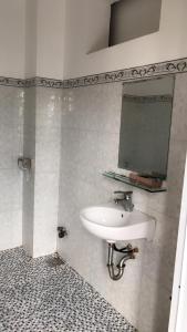 ein Bad mit einem Waschbecken und einem Spiegel in der Unterkunft Nhà Nghỉ Hoàng Hoa in Buon Ma Thuot