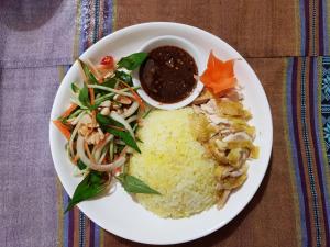 a plate of food with rice and vegetables and a sauce at Mai Châu Home in Mai Châu +37 photos